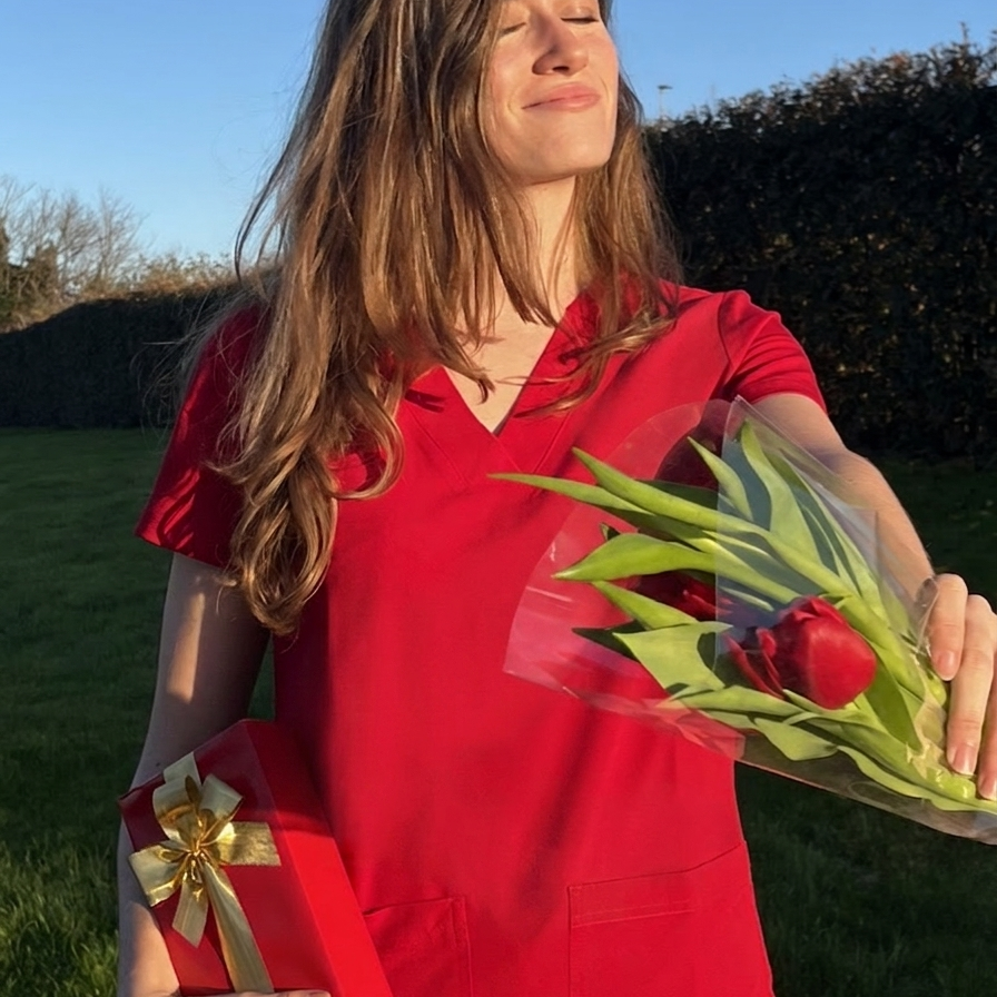 Frau im rotem Kasack mit Blumen und Geschenk an Muttertag