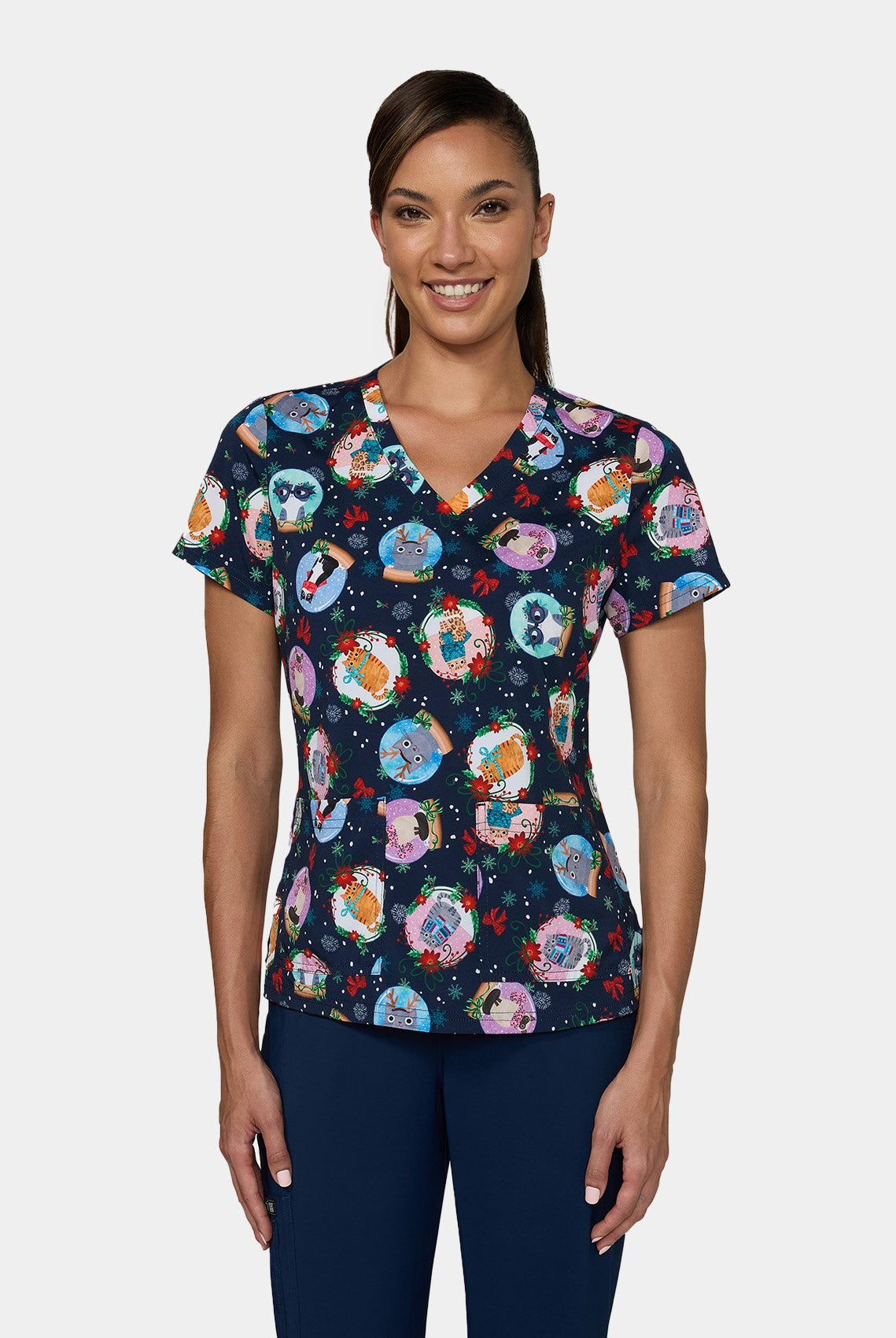 Woman wearing Koi Basics Leslie scrub top with colourful holiday cat print.